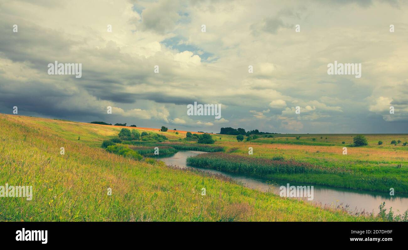 Dark stormy clouds over the fields and meadows Stock Photo - Alamy