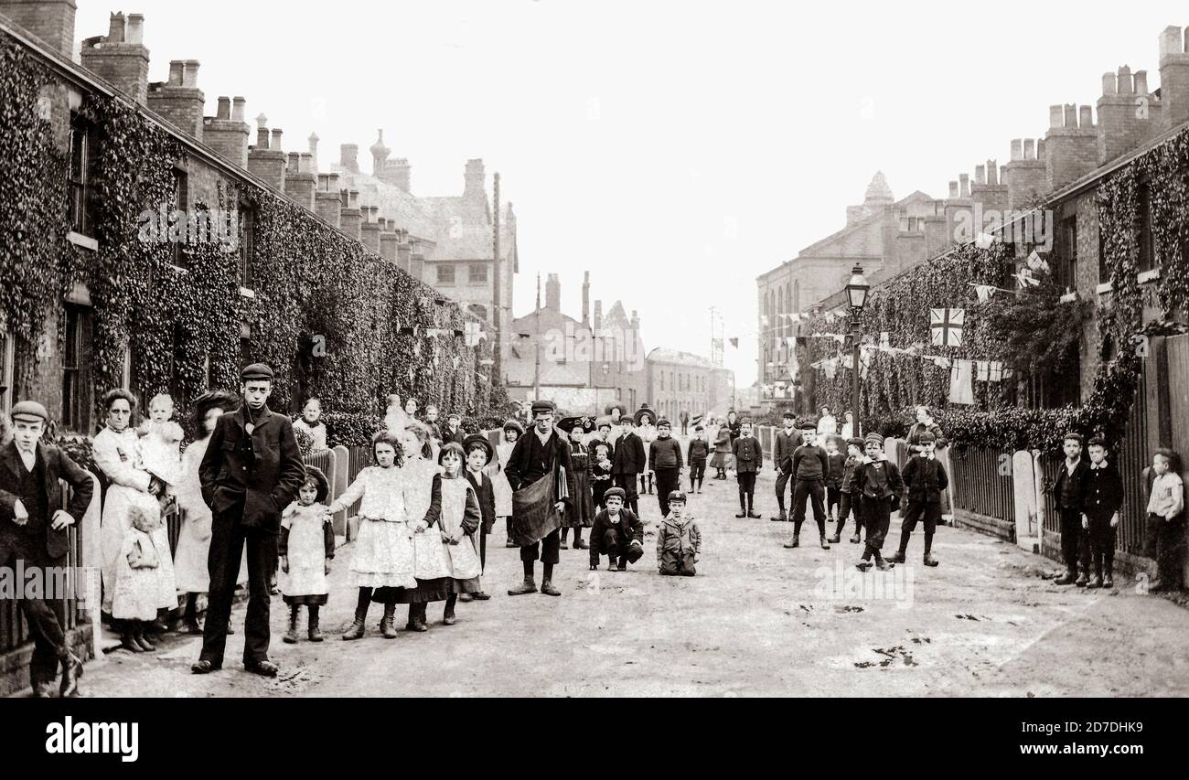 DROYLSDEN STREET SCENE 1907. SHOWING CHILDREN FASHION AND HOUSES INCLUDING A PAPER BOY/NEWSBOY. STREET SCENE SHOWING HOUSES. DROYLSDEN IS IN TAMESIDE, GREATER MANCHESTER. FROM the JOHN STEVEN DUTTON RARE IMAGE COLLECTION. Stock Photo