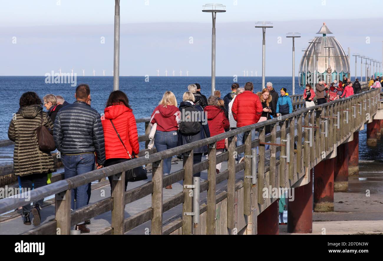 Zingst, Germany. 22nd Oct, 2020. Walkers are on the pier. Plenty of sunshine and temperatures of up to 17 degrees lure the guests into the open air. Credit: Bernd Wüstneck/dpa-Zentralbild/dpa/Alamy Live News Stock Photo