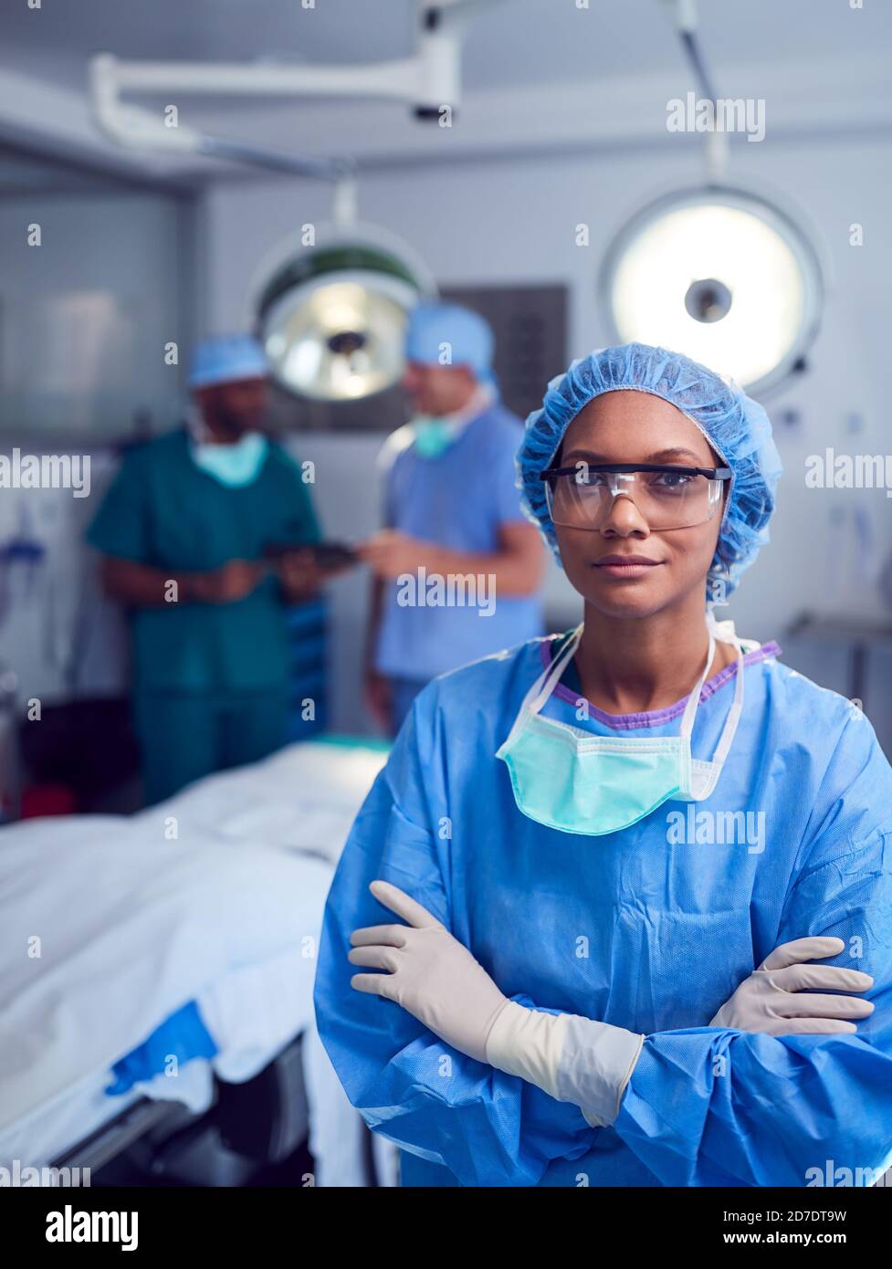 Portrait Of Female Surgeon Wearing Scrubs And Protective Glasses In