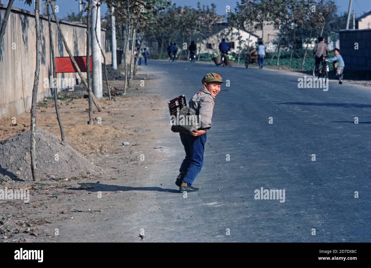 Chinese schoolboy wearing Communist red star cap, on way to school carrying  his abacus, Nanking, China 1980s Stock Photo