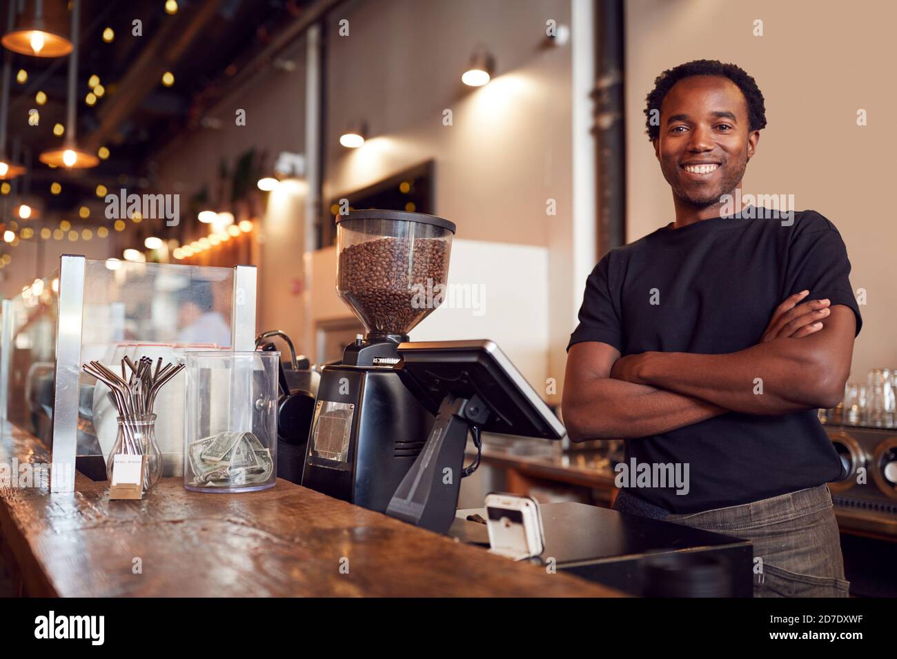 Portrait Of Male Coffee Shop Owner Standing At Sales Desk Stock Photo