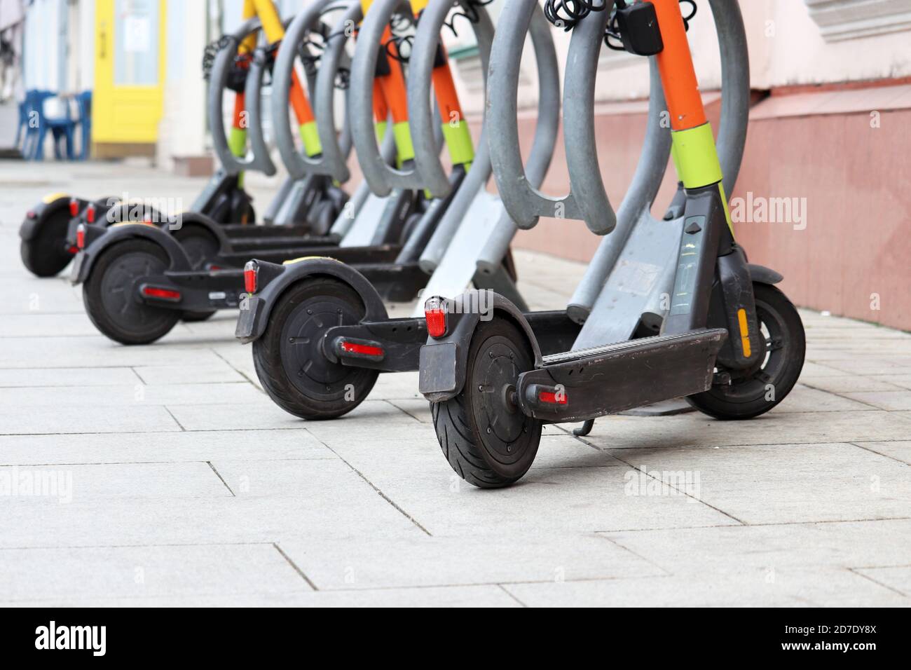 Electric scooters in a row on the parking lot. City bike rental system, public e-scooters on the street Stock Photo