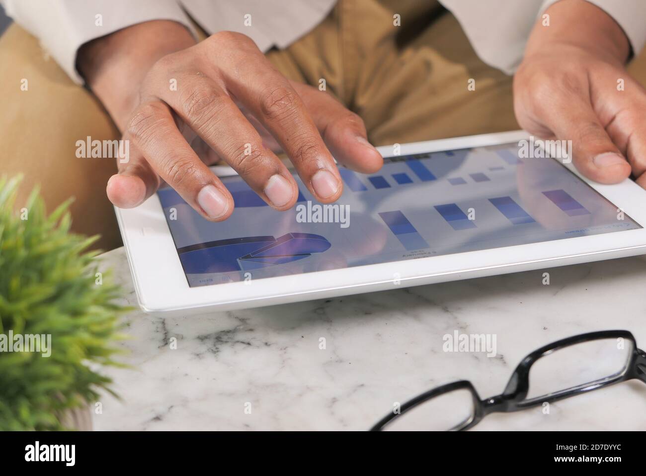 man's hand working on digital tablet at office desk, using self created ...