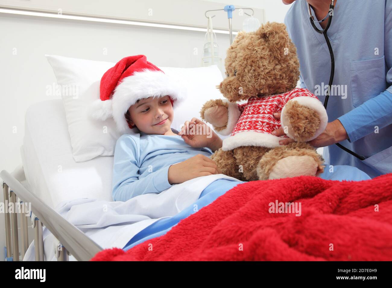 Christmas holiday in hospital happy child lying in bed with Santa Claus ...