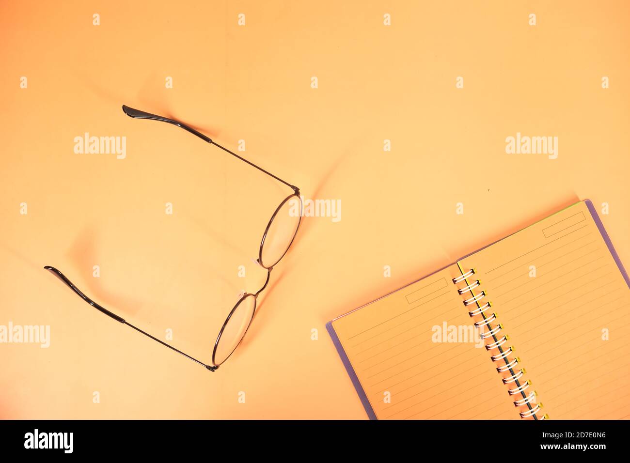 high angle view of open notepad on orange background Stock Photo