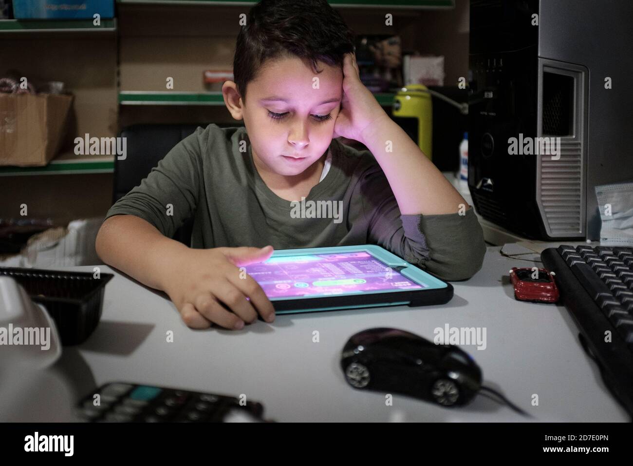 Middle Eastern boy , age 6 playing games on computer tablet Stock Photo