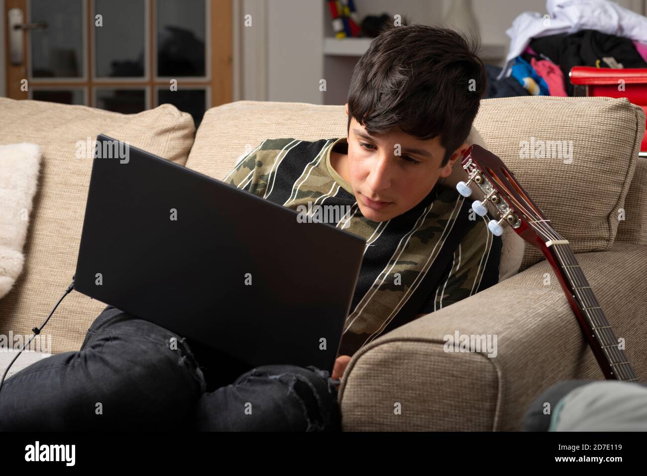 teenage boy, age 13-14 on his laptop at home Stock Photo
