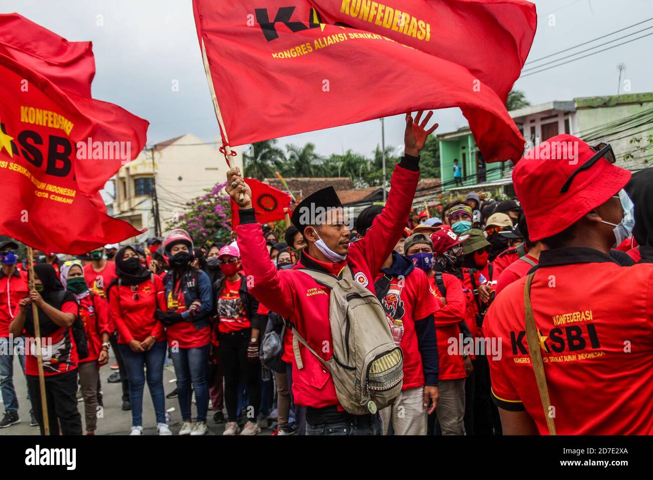 Protesters hold flags during the protest in Rancaekek. Thousands protest against a controversial law 'omnibus' that was passed by Parliament. The new law aims to create jobs and raise investment by reducing regulatory requirements for business permits and land acquisition processes. Many fear, the new law will harm labour rights and indigenous land rights. Stock Photo