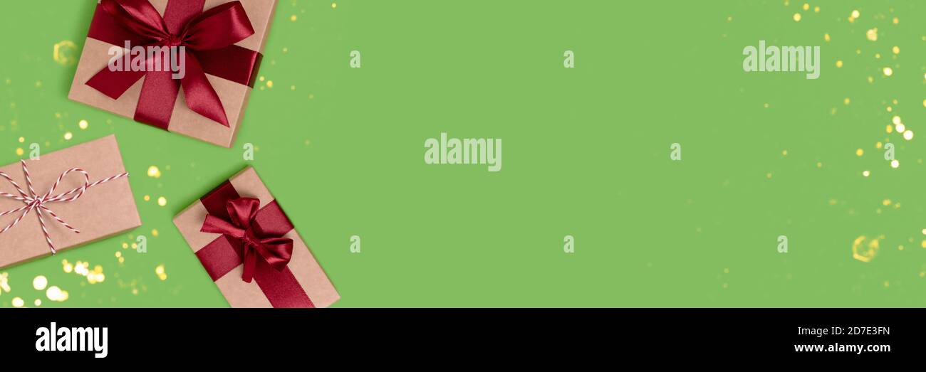 Banner with gift boxes tied with red ribbons on a green background with ...