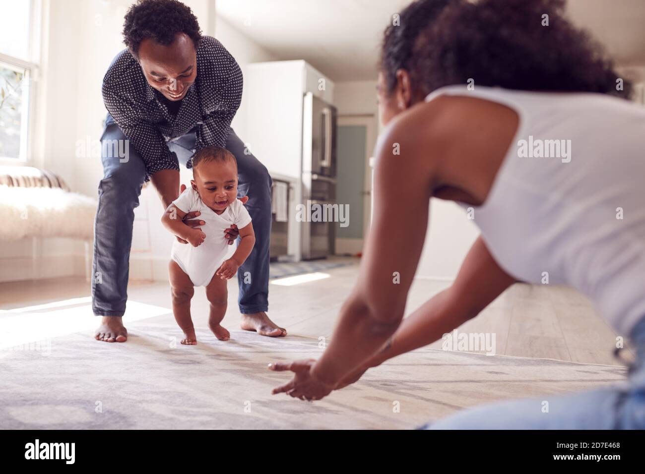 Mother helping baby daughter walk hi-res stock photography and images ...