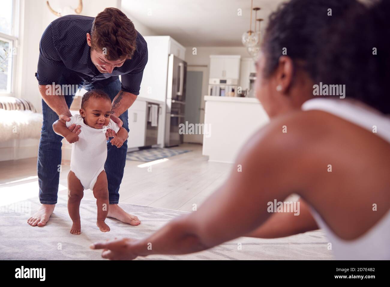 Mother helping baby daughter walk hi-res stock photography and images ...