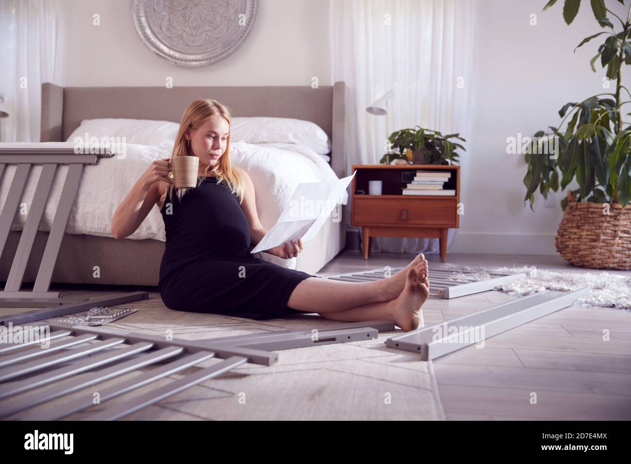 Pregnant Mother To Be Looking At Instructions For Self Assembly Baby