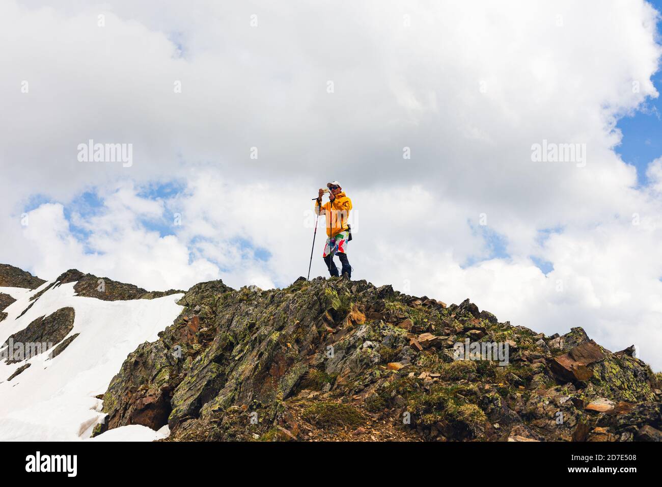 Man hiker using smartphone application navigation in mountains path finding photographing travel blogger influencer lifestyle hiking adventure summer Stock Photo