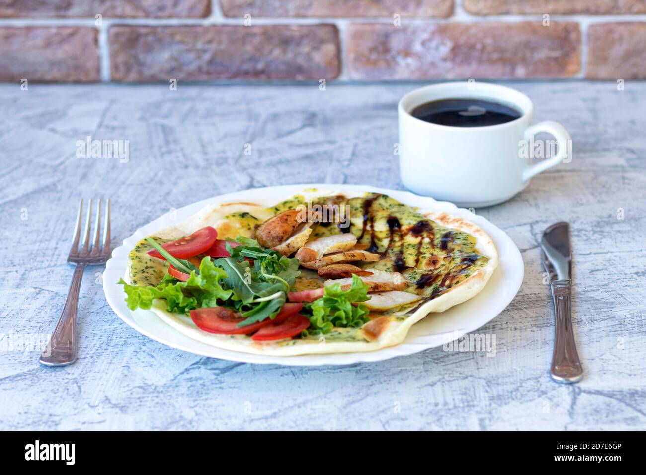 Italian breakfast with coffee. Piadina with grilled chicken, tomatoes, salad and arugula. Delicious breakfast served on table. Soft focus Stock Photo