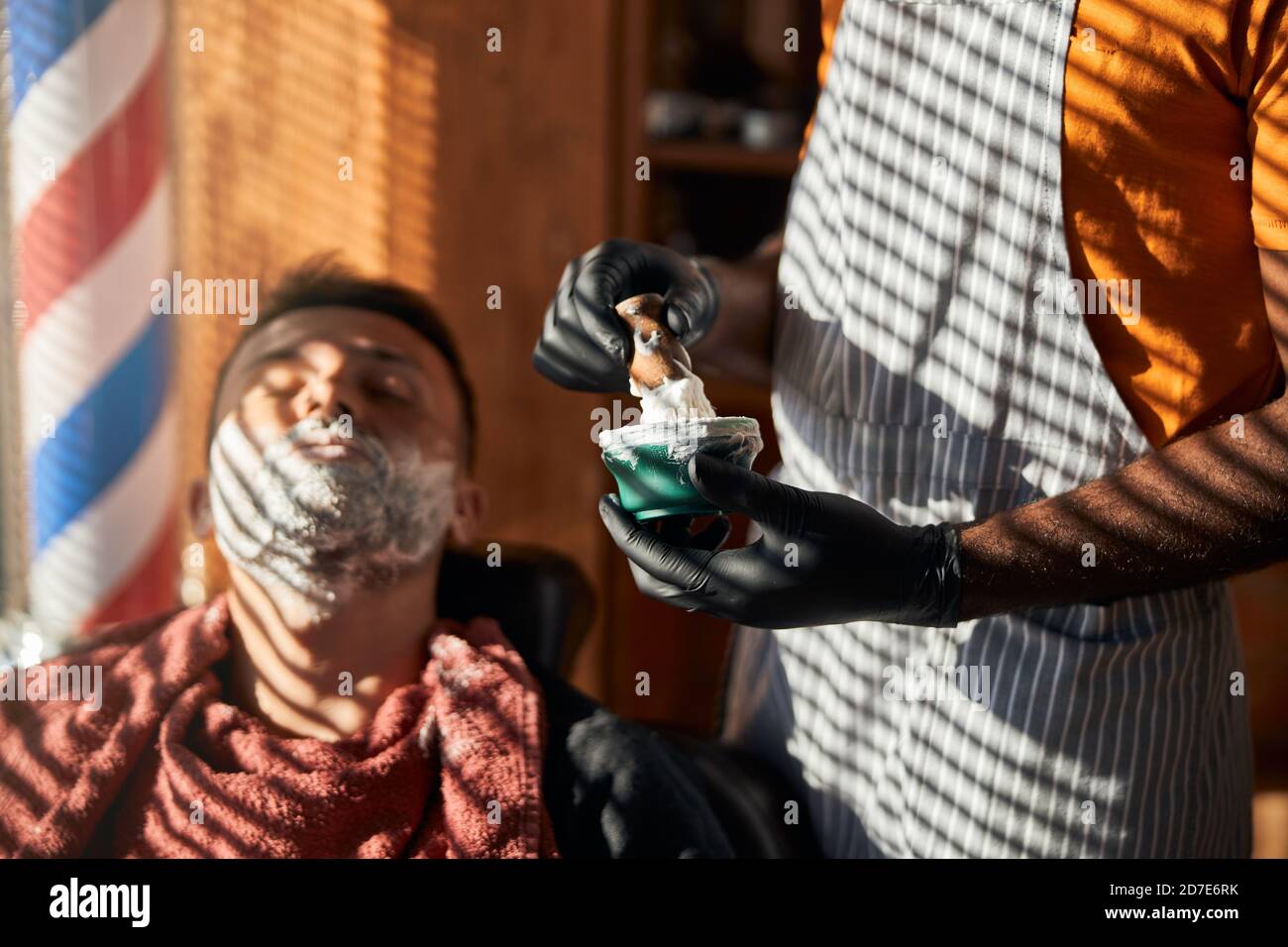 Barber in sterile gloves preparing shaving cream in Stock Photo Alamy