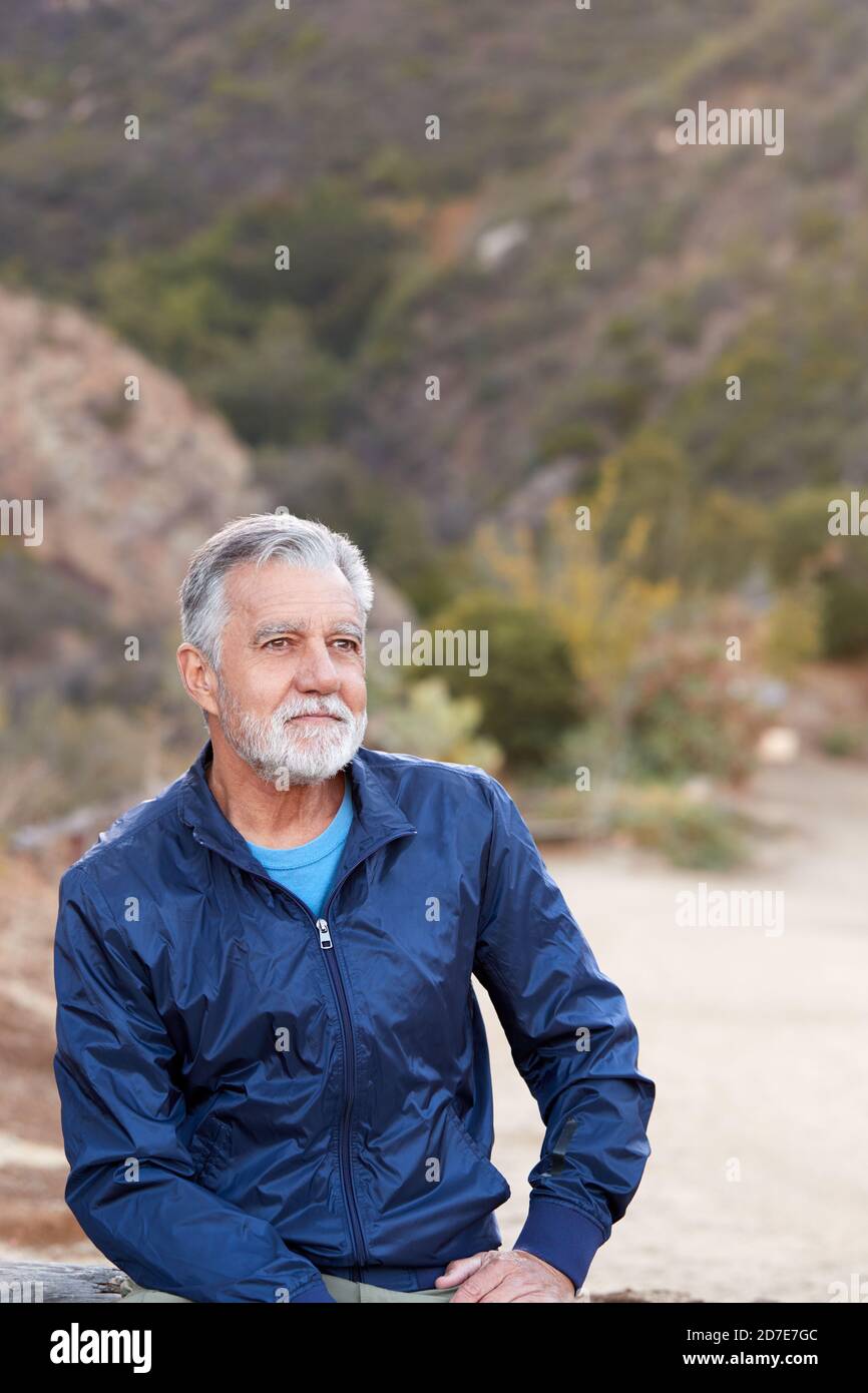 Outdoor Portrait Of Serious Hispanic Senior Man With Mental Health Concerns Stock Photo