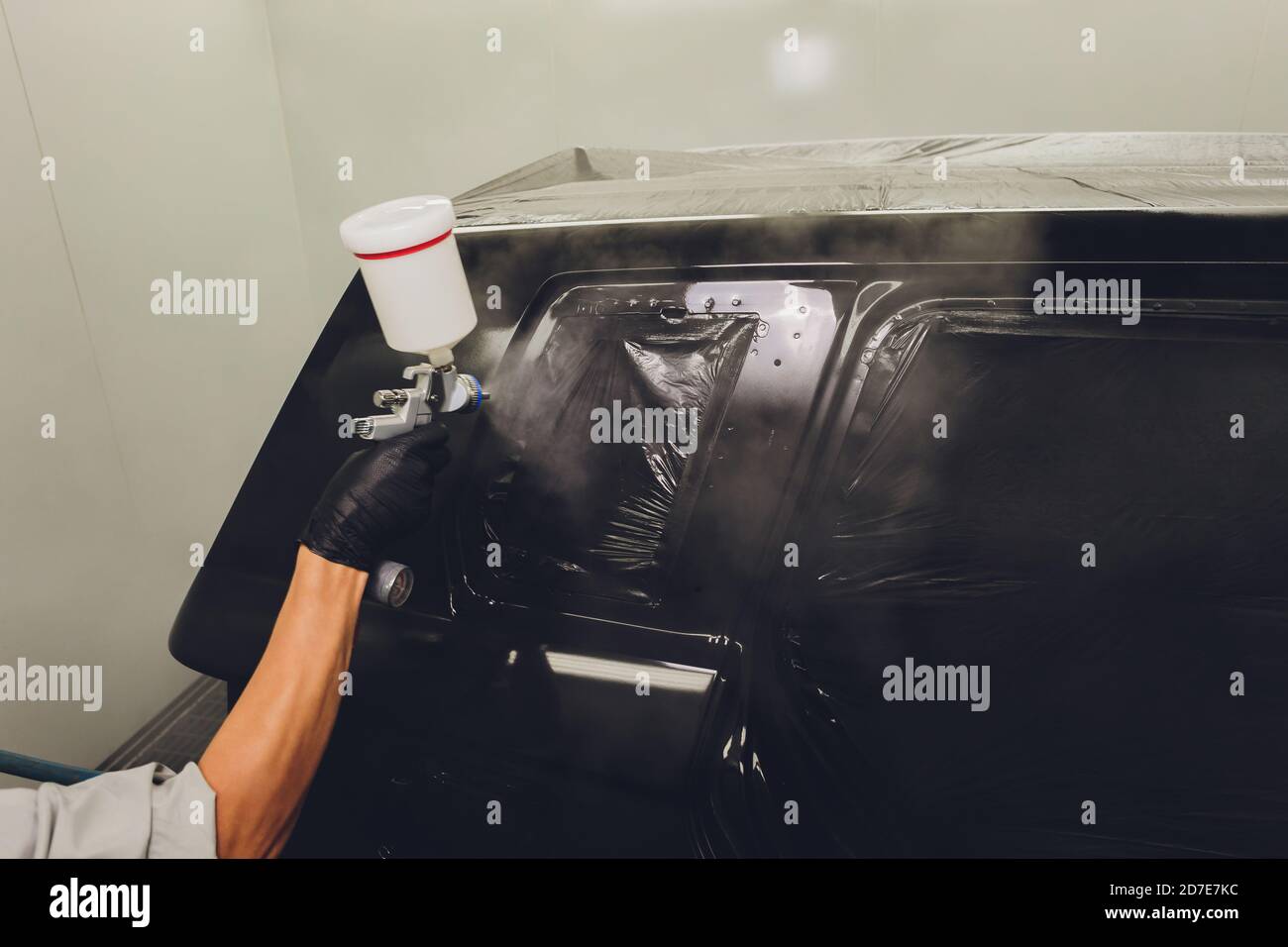 Worker painting a car in a paint booth Stock Photo Alamy