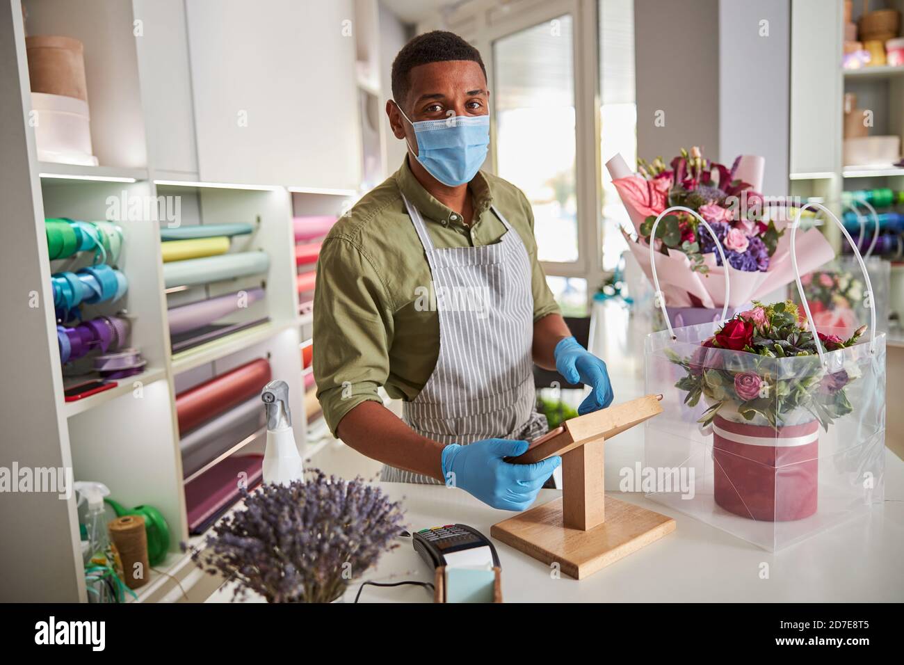 Flower shop worker making calculations on an electronic tablet Stock