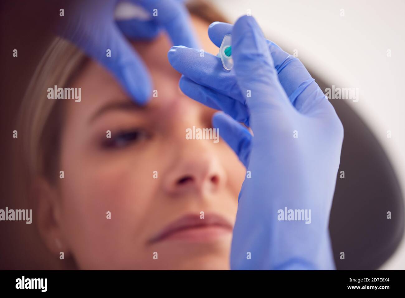 Woman Sitting In Chair Being Give Botox Injection Between Eyes By ...