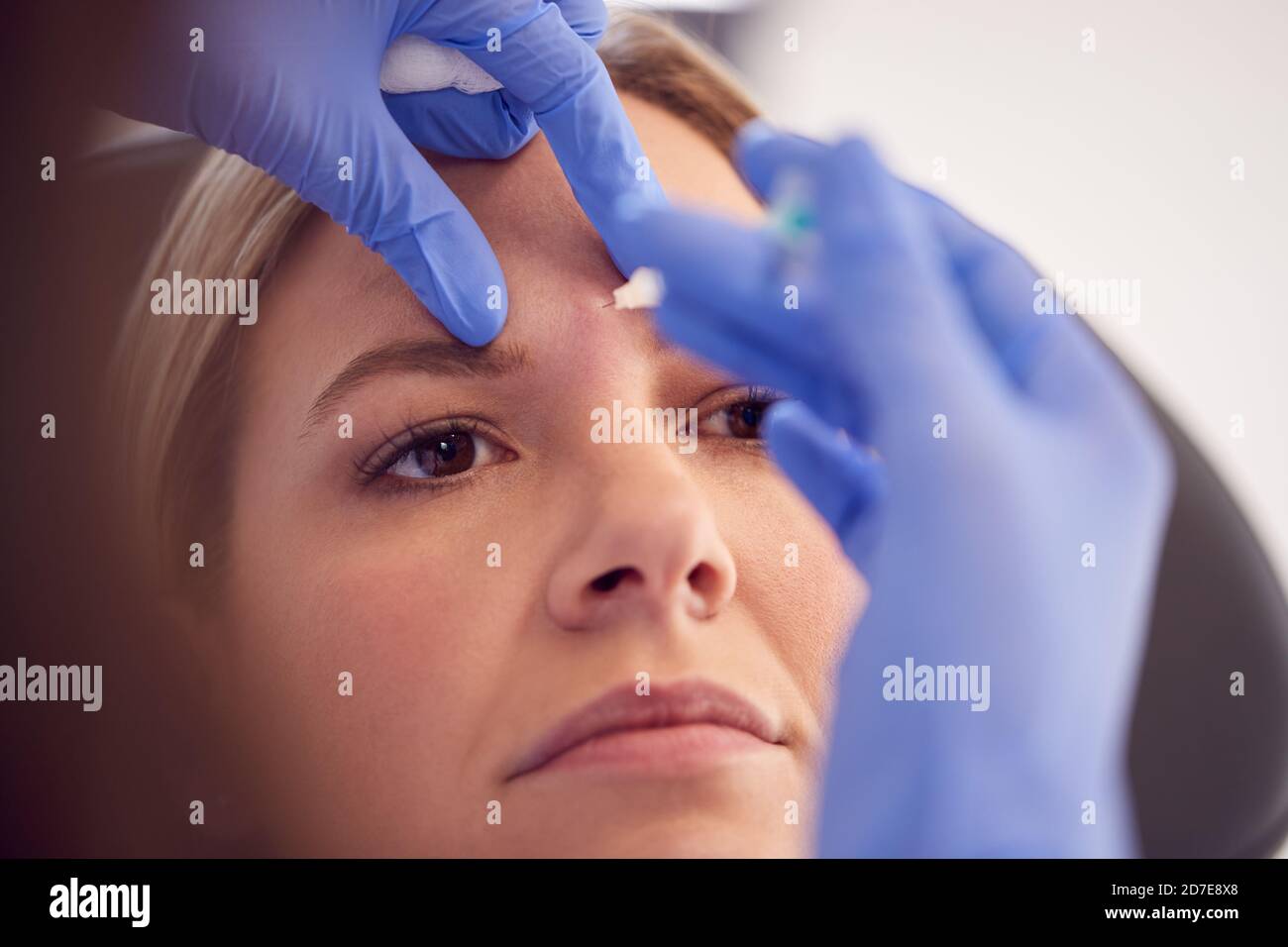 Woman Sitting In Chair Being Give Botox Injection Between Eyes By ...