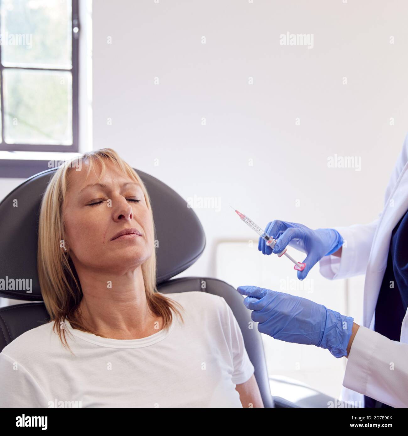 Mature Woman Sitting In Chair Being Give Botox Injection By Female ...