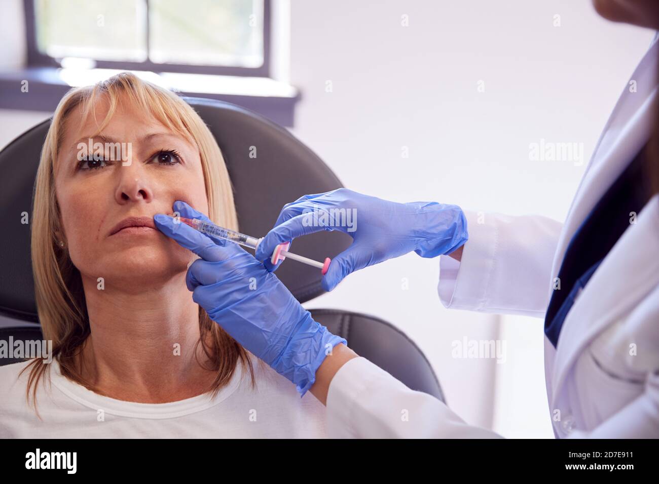 Mature Woman Sitting In Chair Being Give Botox Injection By Female ...