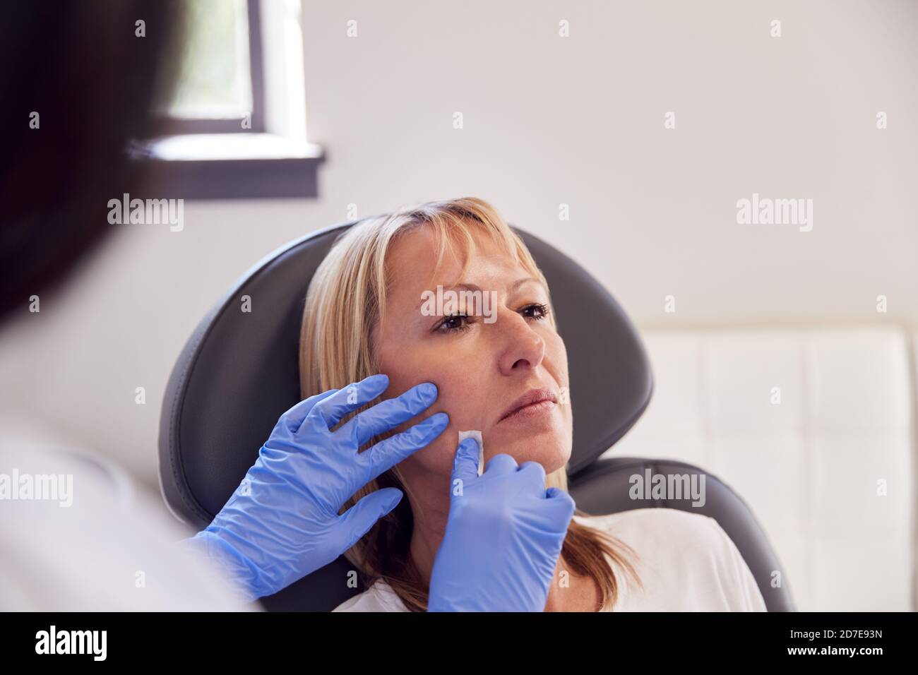 Mature Woman Sitting In Chair Being Give Botox Injection By Female ...