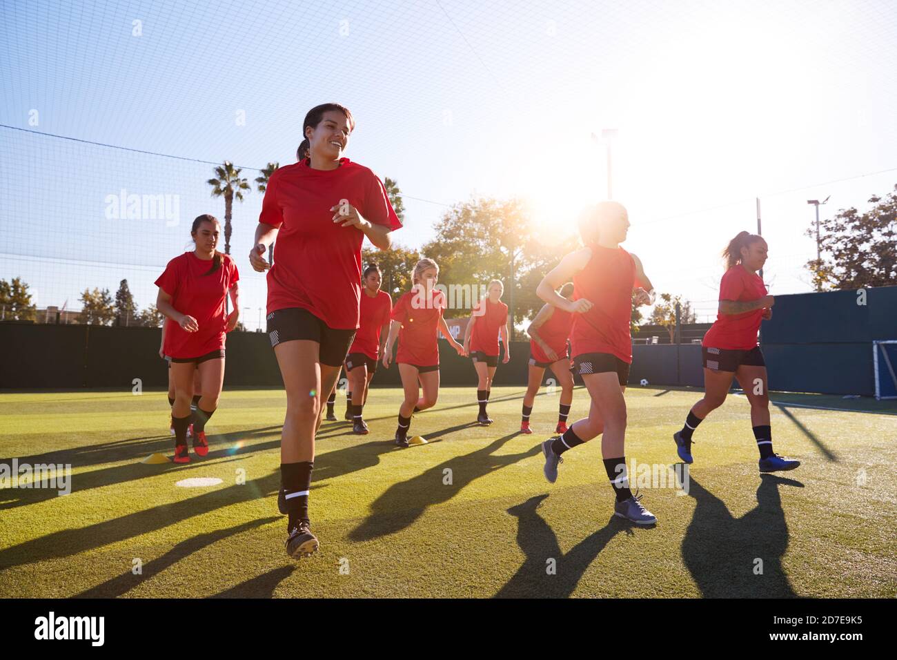Womens Football Team Run Whilst Training For Soccer Match On Outdoor Astro  Turf Pitch Stock Photo - Alamy
