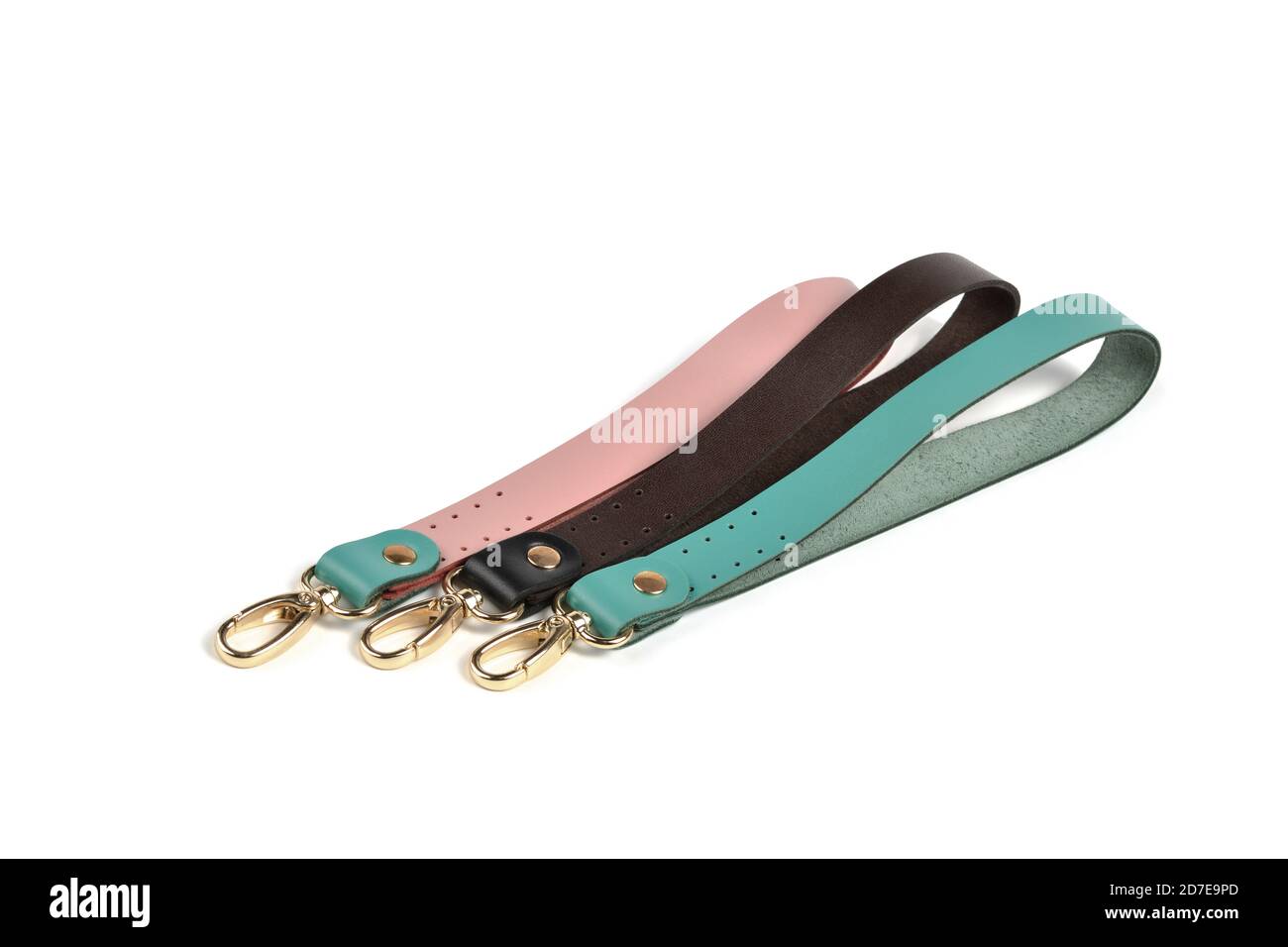 Blank loop pink green brown gray color leather key chain collection on isolated white background with clipping path. Pile set of metallic souvenir. Stock Photo