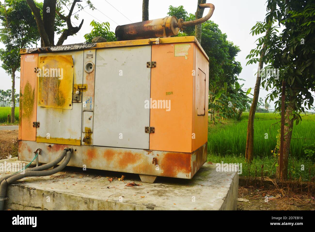 Close up of a old big electric generator set with rusted cover on a
