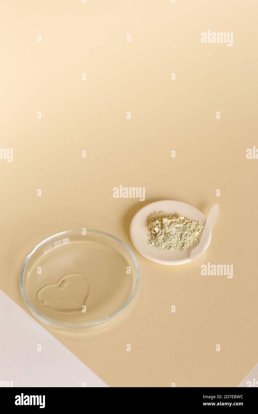 Clay powder and water in glass jar on light background with copy space