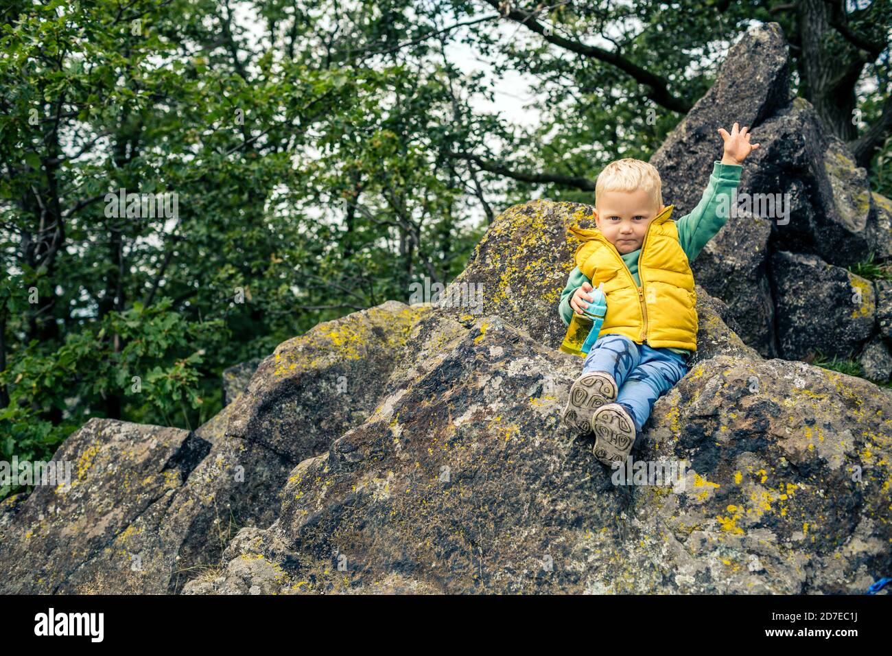 Little boy hiking in mountins, small adventure. Child in rocky green forest having fun. Stock Photo