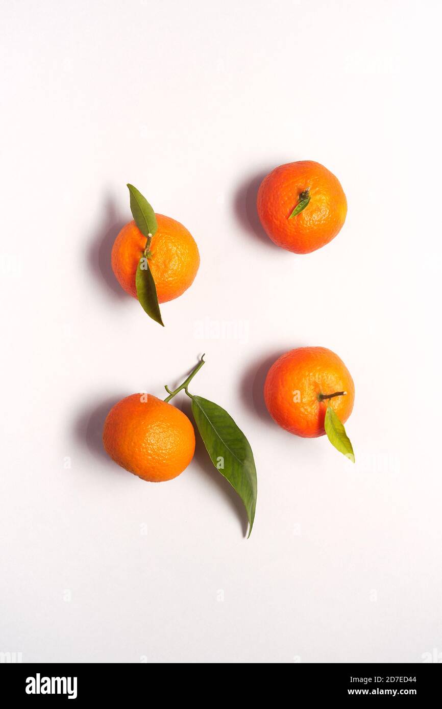 Overhead View Of Fresh Satsumas With Leaves Against White Background