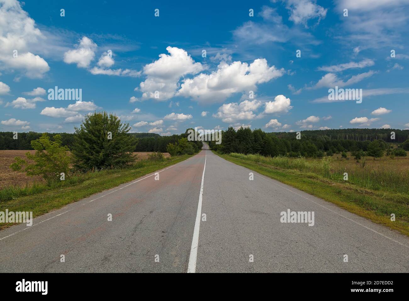 Asphalt road on a background of blue sky with clouds Stock Photo - Alamy
