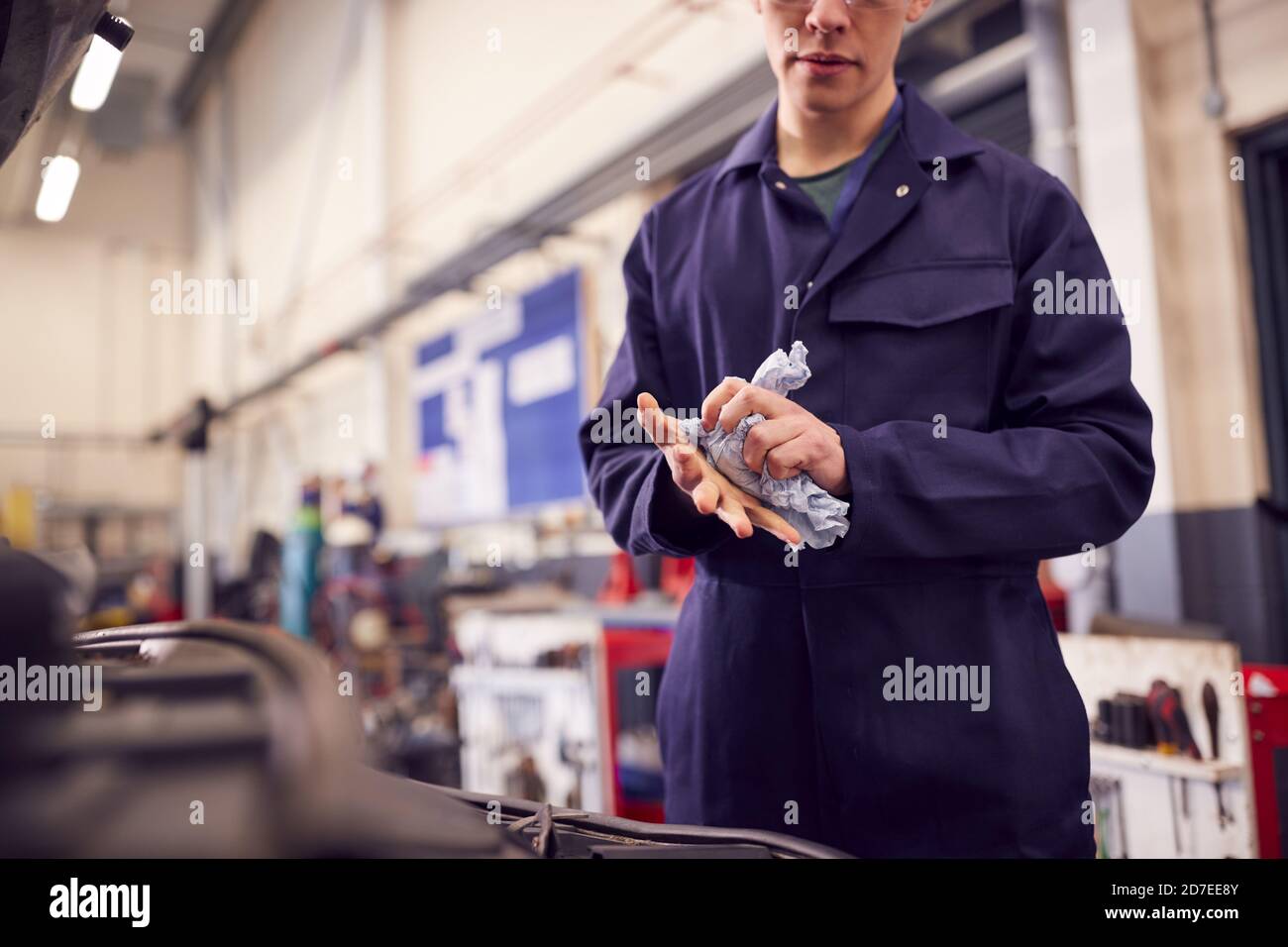 Close Up Of Male Motor Mechanic Wiping Hands After Working On Car Engine In Garage Stock Photo
