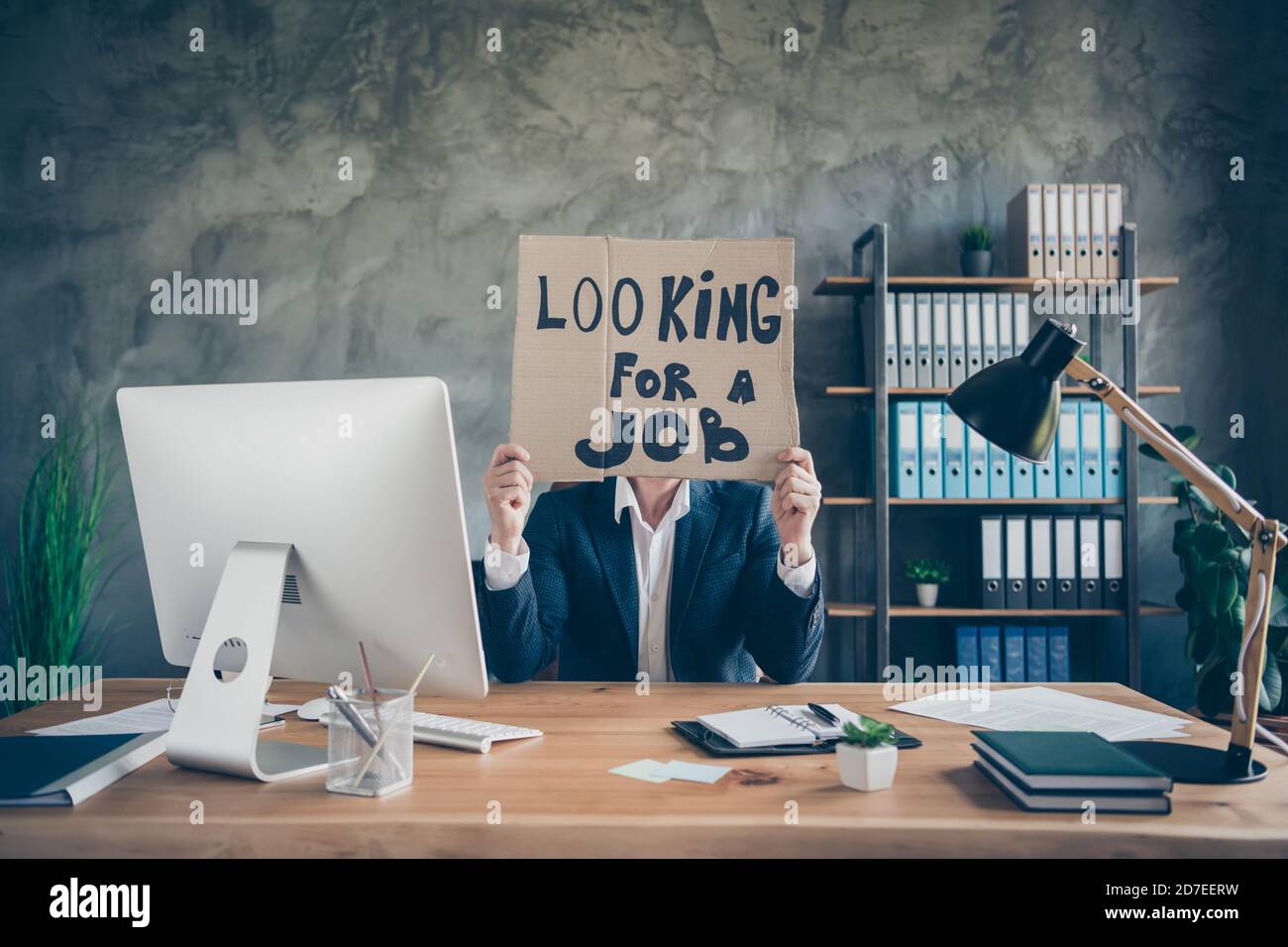 His he fired poor finance agent broker guy holding in hands promo placard hiding face looking new chance job economy investment insurance at loft Stock Photo
