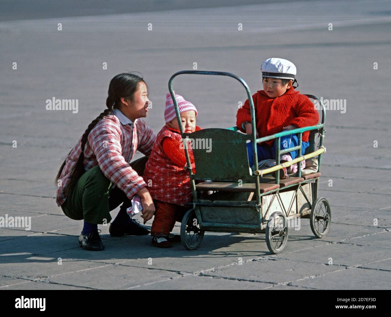 Chinese mother with 2 children and wooden pram in Tianamen Square, Beijing, China, 1980 Stock Photo