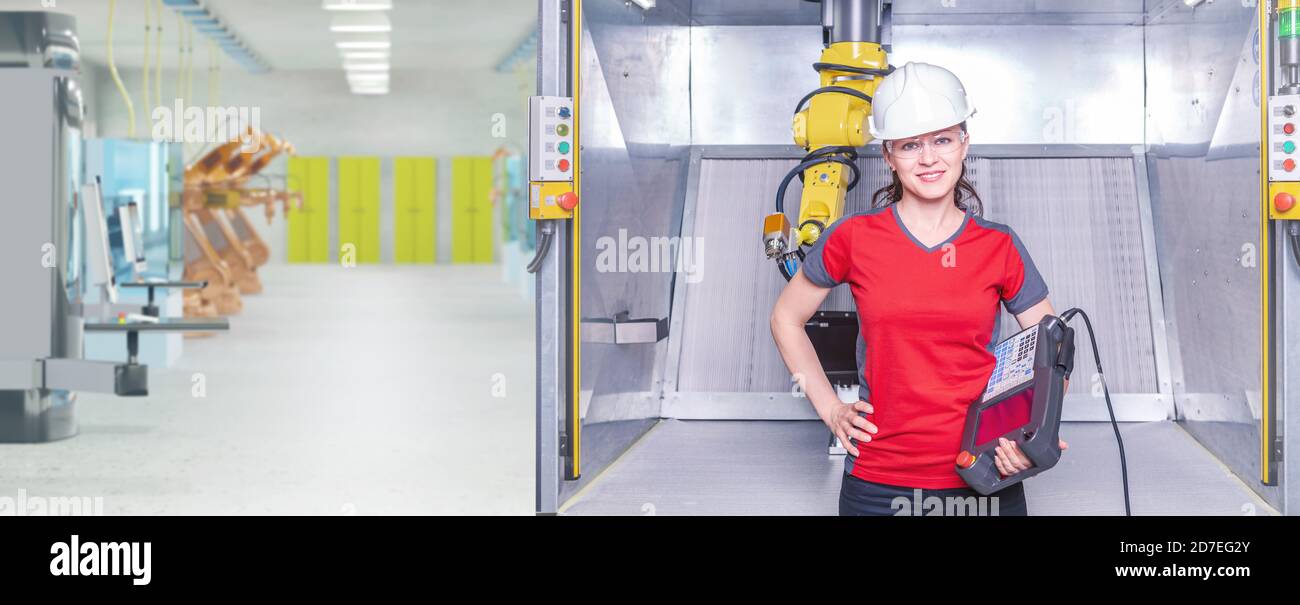 A young female technician while machine constructing in a manufacturing plant Stock Photo