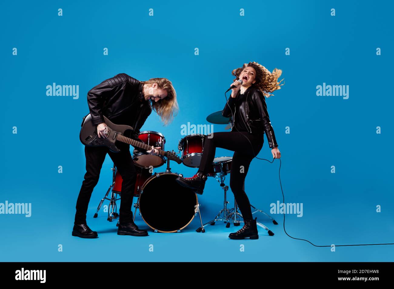 Full length photo of crazy funky two people rock band team man play bass  guitar woman sing mic song solo popular rhythm isolated over bright shine  Stock Photo - Alamy