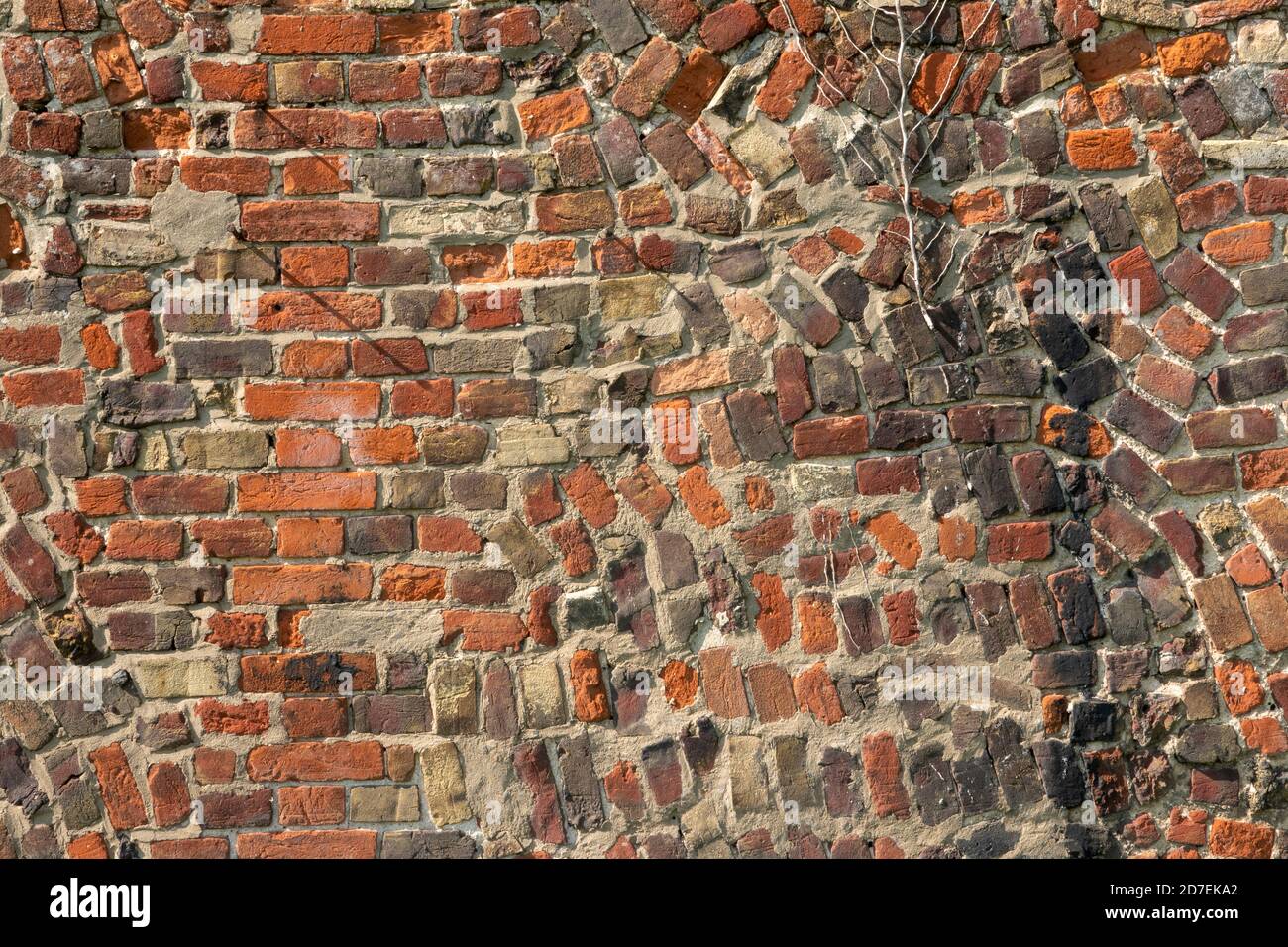 A section of antique red brick wall with random construction Stock Photo