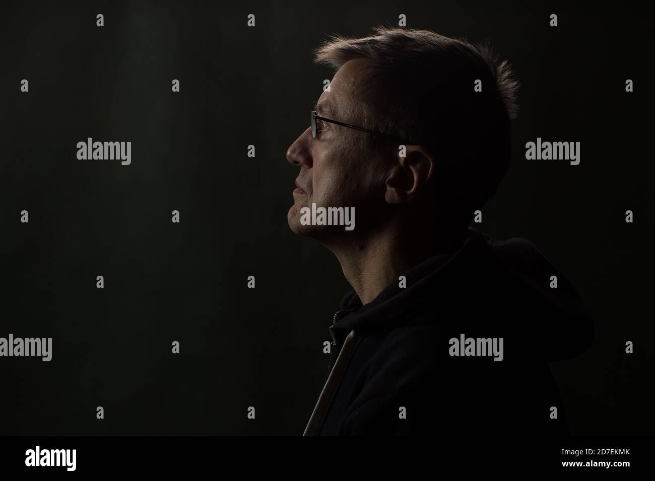 Low key portrait of mid adult man wearing glasses. Stock Photo