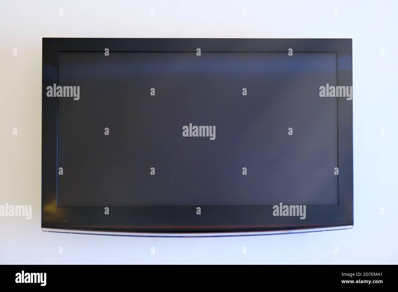 Black big television on white wall, mockup Stock Photo