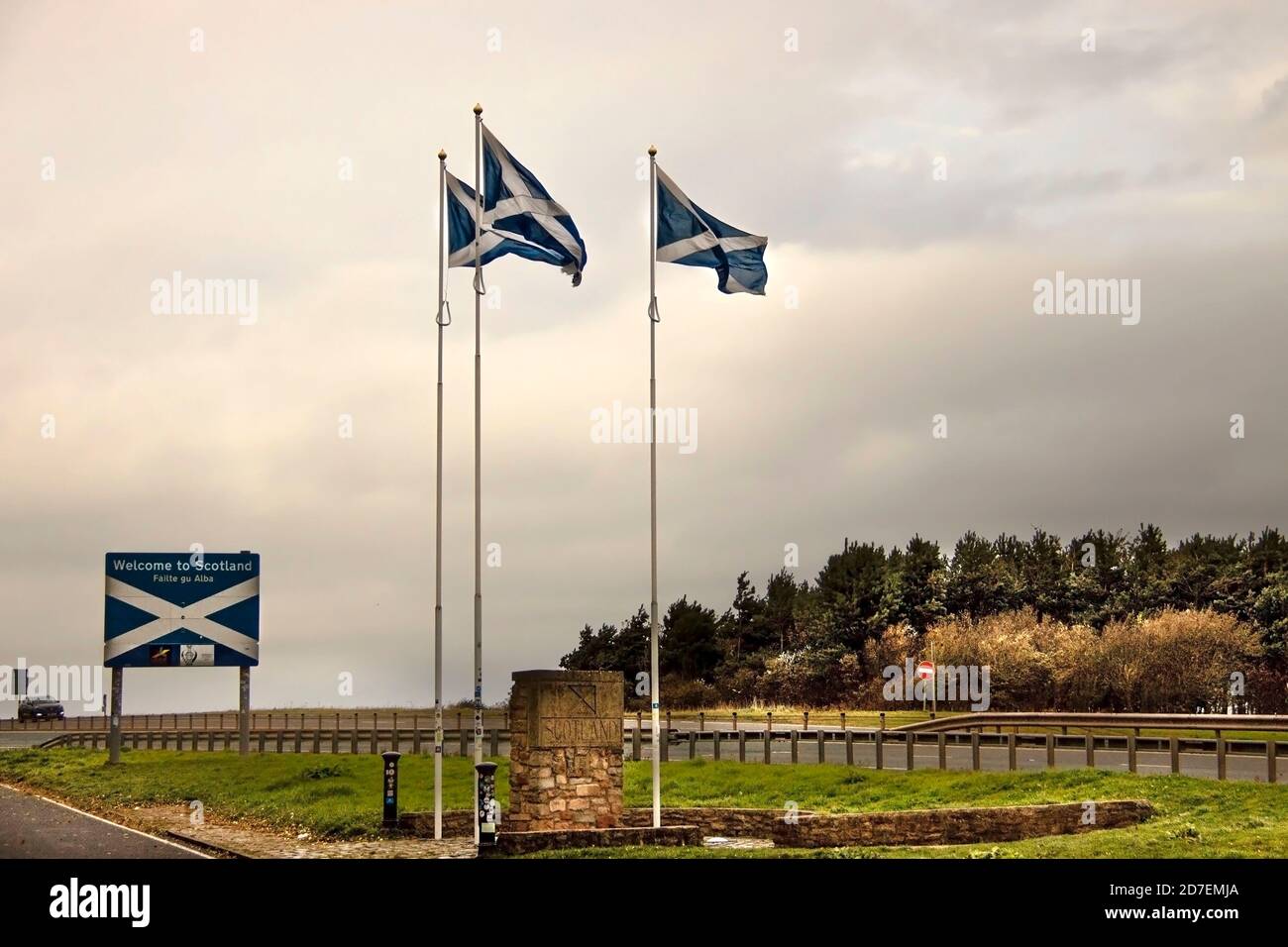 Scotland and England border with Scottish flags and welcome to Scotland sign. Stock Photo