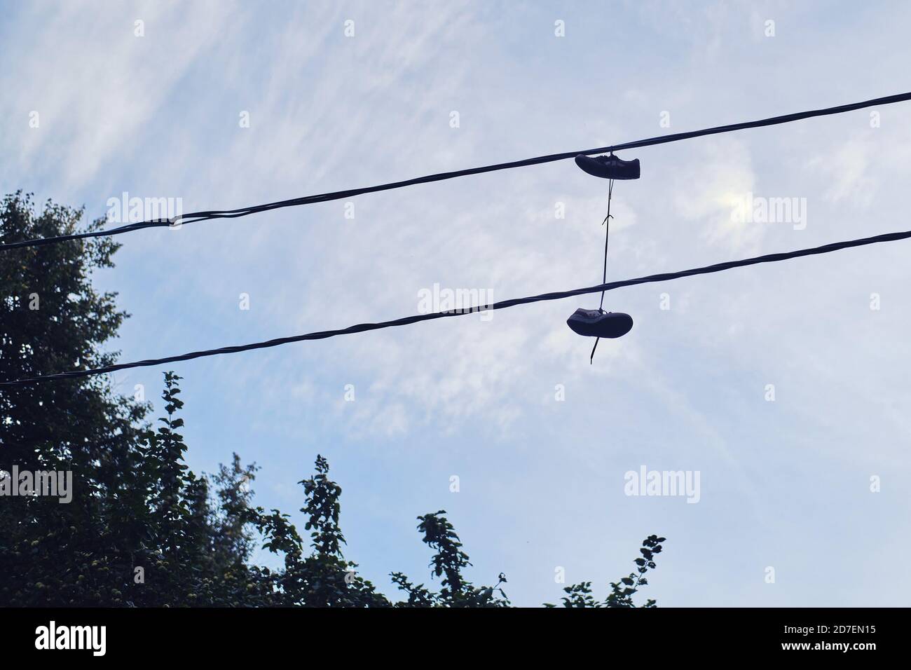 Shoes hanging on electric wires on the street Stock Photo - Alamy