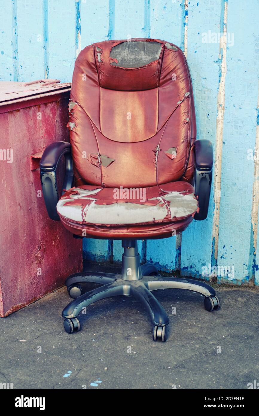Old leather computer chair thrown into the street, bankrupt concept and business problems Stock Photo