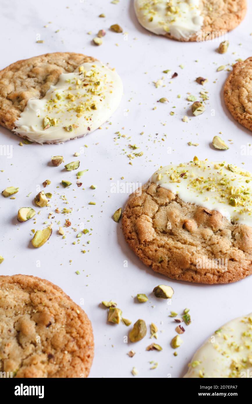 White chocolate and pistachio cookies placed on a white marble tabletop. Stock Photo