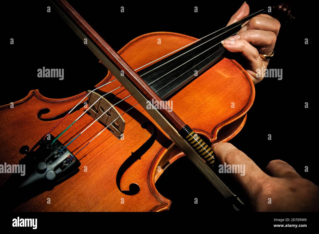 Hands playing a violin on black background cropped closeup Stock Photo