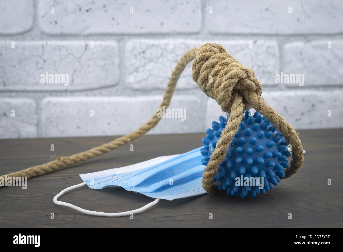 Rope noose around a virus molecule and protective surgical face mask conceptual of death or mortality during the global Covid-19 or coronavirus pandem Stock Photo