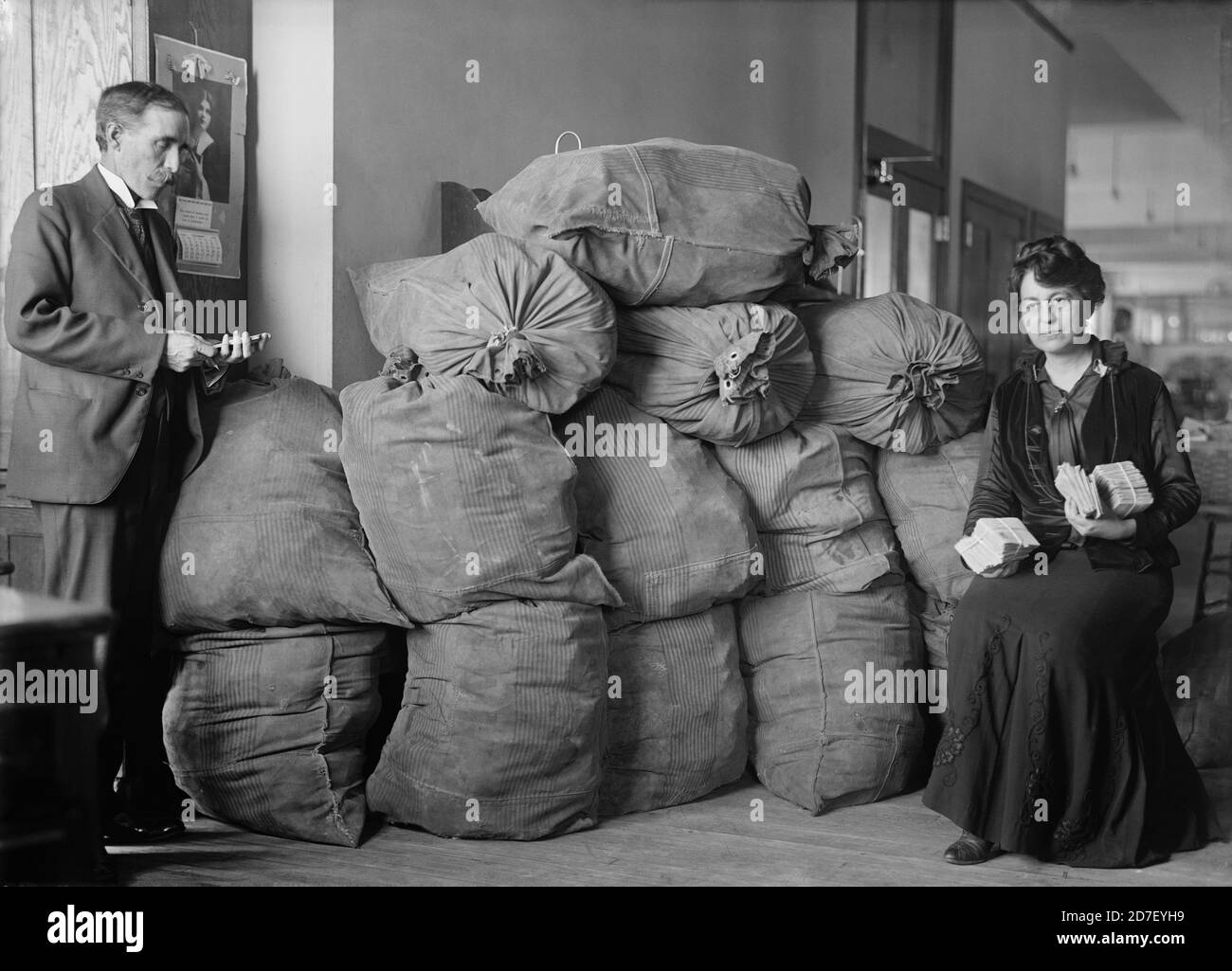 Supt. Marvin McLean and Mrs. Clara R.A. Nelson with Bags of Dead Letter Mail, U.S. Post Office, Washington, D.C., USA, Harris & Ewing, October 1916 Stock Photo